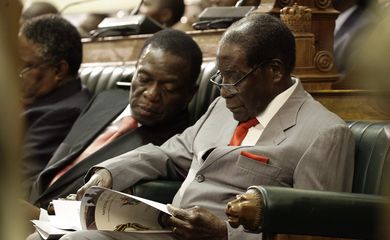 O presidente do Zimbábue, Robert Mugabe (direita), é acompanhado pelo vice-presidente Emmerson Mnangagwa (esquerda),  na Câmara do Parlamento, em Harare - Foto Agência Lusa
