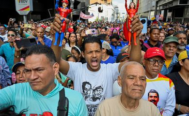 A demonstrator holds action figures of 