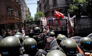 Forças armadas argentinas contêm manifestantes, nos arredores do Congresso em Buenos Aires, que protestam contra a votação da reforma da Previdência no país