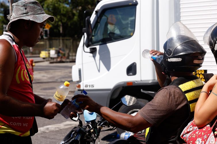 Rio de Janeiro (RJ), 17/02/2024 -Transeuntes se protegem do forte calor nas ruas do centro da cidade. Cidade do Rio de Janeiro atinge nível 4 de calor. Marco é caracterizado por temperaturas que podem chegar a 44ºC  Foto: Tânia Rêgo/Agência Brasil