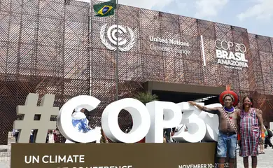 Belém (PA), 12/11/2025 - Indígenas tiram foto em frente a fachada do pavilhão na COP30. Foto: Bruno Peres/Agência Brasil