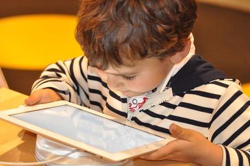Criança observa tela de um tablet