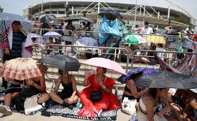 People holding umbrellas wait for the Taylor Swift concert, following the death of a fan due to the heat during the first day concert, in Rio de Janeiro, Brazil, November 18, 2023. REUTERS/Pilar Olivares