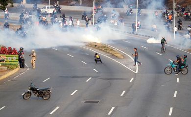 Partidários da oposição venezuelana reagem ao gás lacrimogêneo perto da Base Aérea 