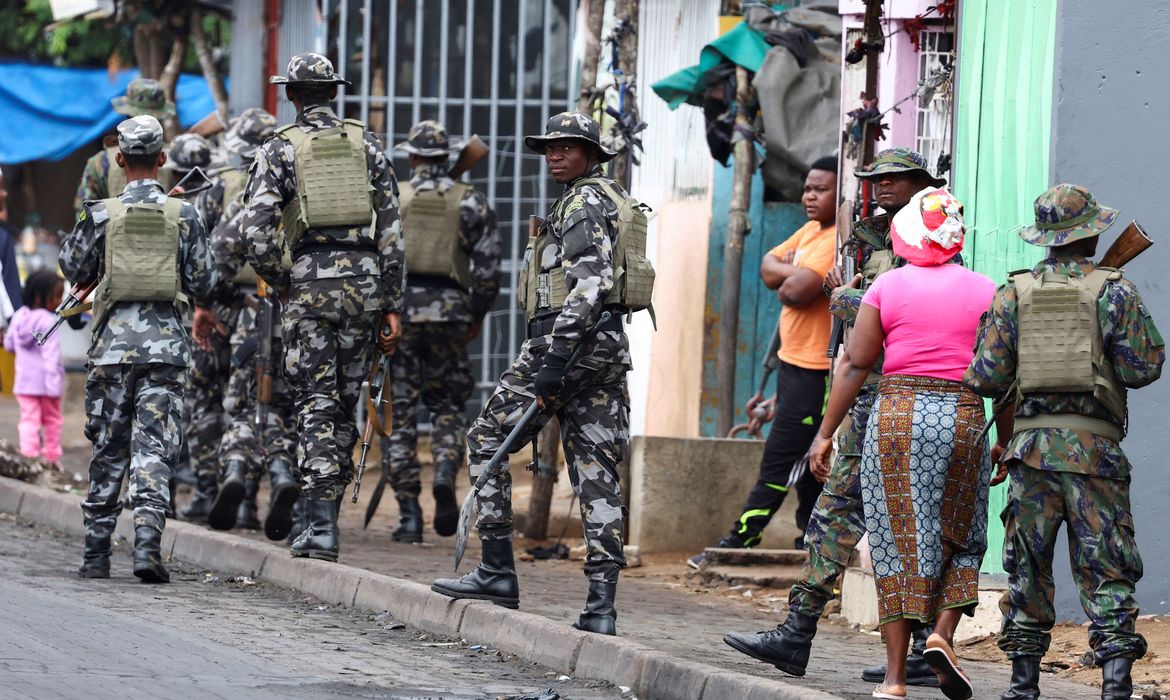 FILE PHOTO: A member of the Mozambique military, looks on as they patrol the streets of the capital a day after a 
