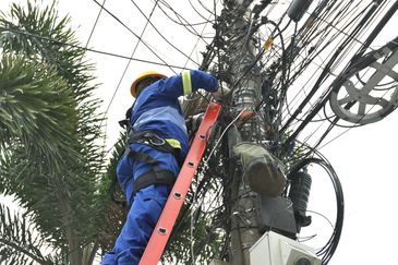 Funcionários da Rioluz trabalham na retirada de fios em Benfica, zona norte da cidade. Prefeitura lança programa Caça-Fios, uma força-tarefa para eliminar fiações que ficam soltas, partidas e caídas nas vias da cidade.