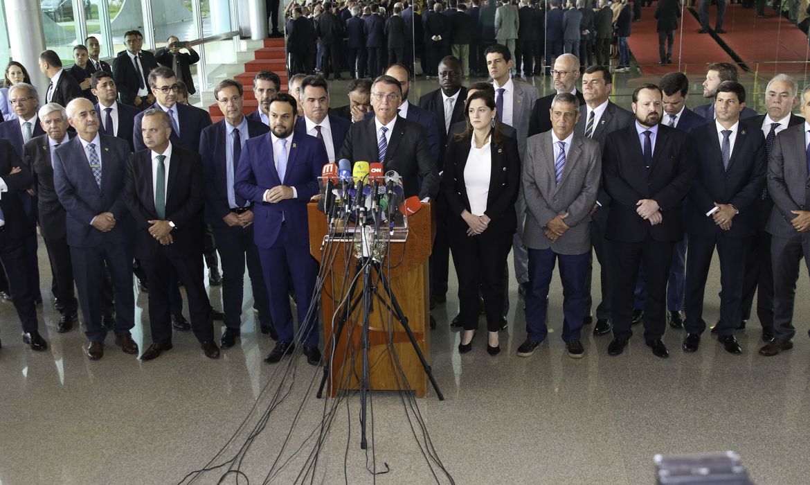 Presidente Jair Bolsonaro, acompanhado de vários ministros, fala com a imprensa no Palácio da Alvorada