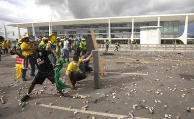 Brasilia 07/02/2023 - Manifestantes invadem predios publicos na praca dos Tres Poderes, na foto manifestantes arrastam grades que ficam na frente do Palacio do Planalto