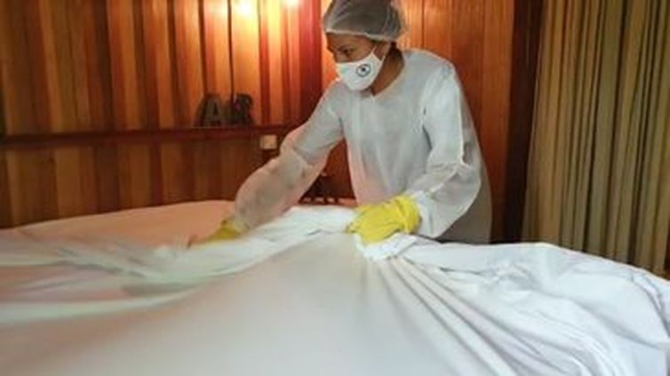 Camareira de hotel faz a higienização contra covid-19