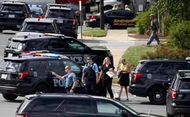 Policiais vigiam cena do crime após homem atirar em direção ao jornal Capital Gazette, em Annapolis, Maryland, Estados Unidos, e matar ao menos cinco pessoas.