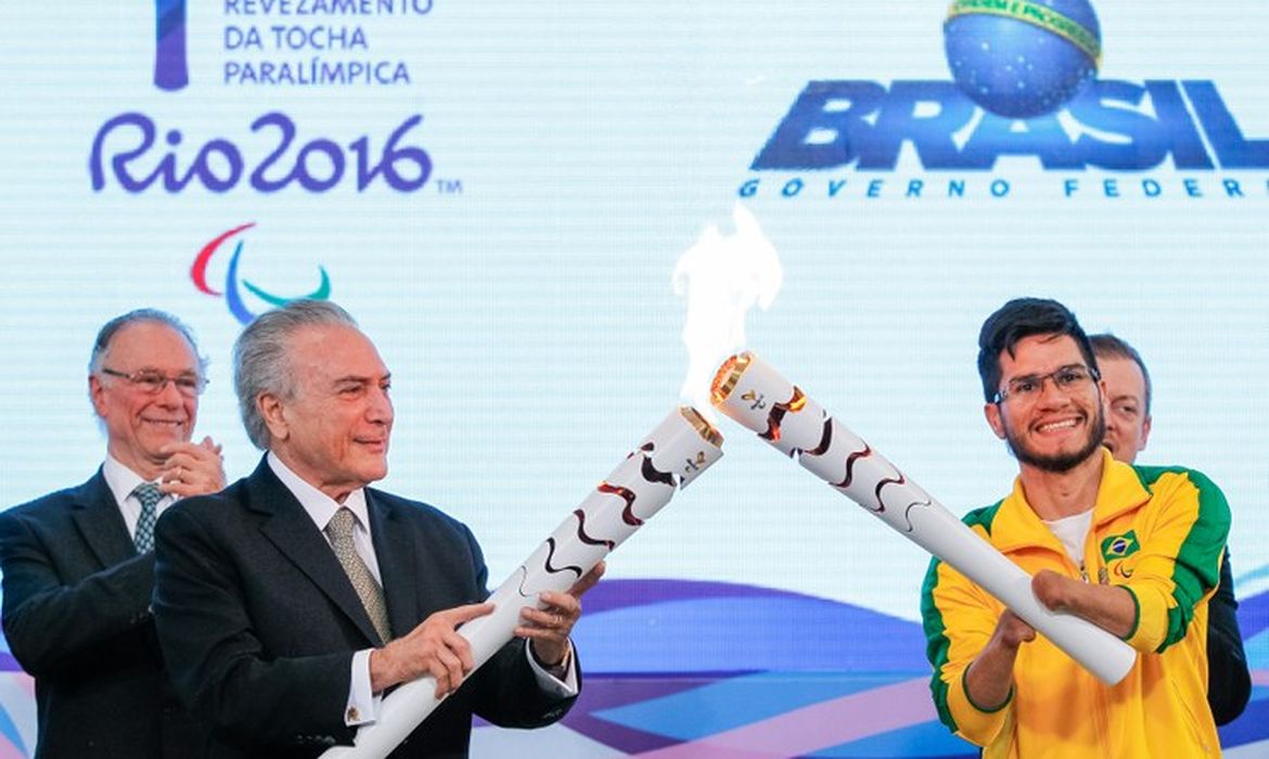 O presidente interino Michel Temer e o velocista Yohansson Nascimento acendem a tocha paralímpica no Palácio do Planalto
