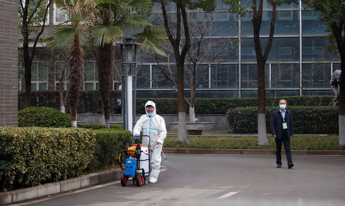 01/01/2021 Funcionário com traje de proteção desinfecta pavimento antes de chegada de equipe da OMS a centro de prevenção de doenças animais em Wuhan