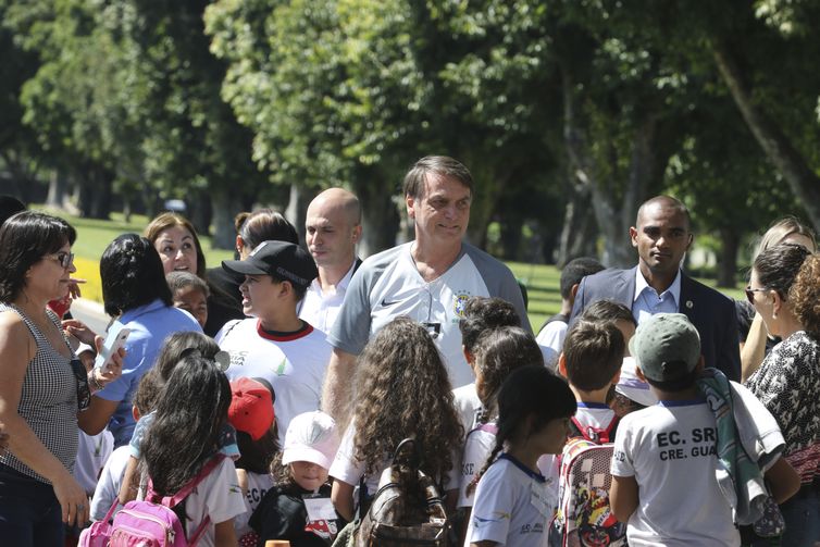 O presidente Jair Bolsonaro vem até a entrada do Palácio da Alvorada, e conversa com crianças e posa para fotos.