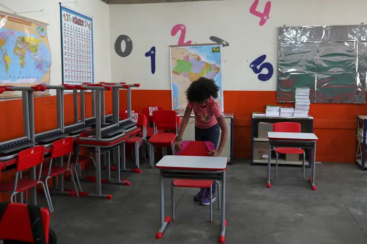 Criança pendura mochila na cadeira de sala de aula da escola Thomaz Rodrigues Alckmin, no primeiro dia de retorno das escolas do estado de São Paulo para atividades extracurriculares em meio ao surto de coronavírus (COVID-19) em São Paulo,