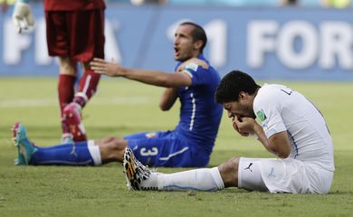 Italy's Giorgio Chiellini complains after Uruguay's Luis Suarez ran into his shoulder with his teeth during the group D World Cup soccer match between Italy and Uruguay at the Arena das Dunas in Natal, Brazil, Tuesday, 