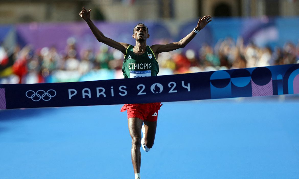 Paris 2024 Olympics - Athletics - Men's Marathon - Paris, France - August 10, 2024. Tamirat Tola of Ethiopia celebrates as he crosses the finish line at Invalides to win gold. REUTERS/Isabel Infantes     TPX IMAGES OF THE DAY