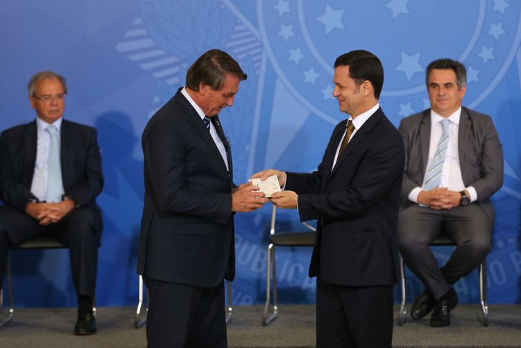 Justice Minister Anderson Torres hands over the new passport to President Jair Bolsonaro during a ceremony for the issuance of new national identity cards in the states and the launch of the new passport for Brazil.