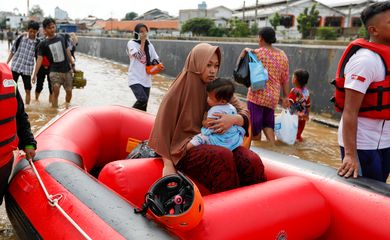 Woman holds a child as they are evacuated by an inflatable boat, at an area affected by floods after heavy rains in Jakarta, Indonesia, January 2, 2020. REUTERS/Willy Kurniawan