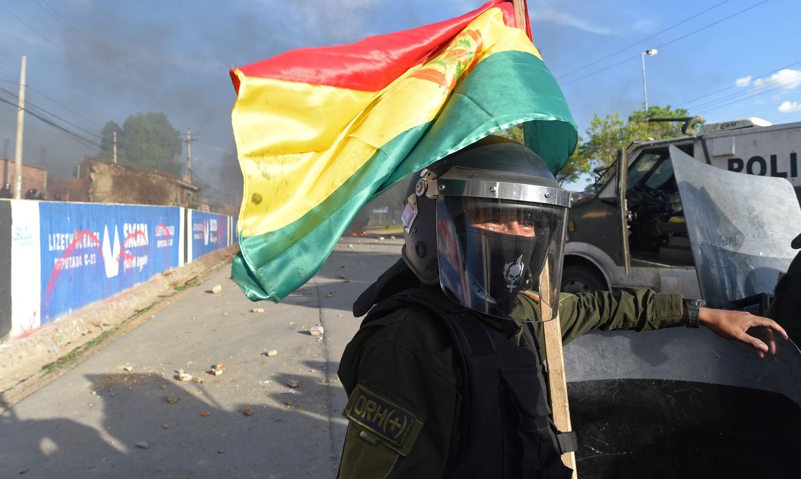 A riot police officer with a Bolivian flag is seen in Sacaba, on the outskirts of Cochabamba, Bolivia, November 15, 2019. REUTERS/Danilo Balderrama