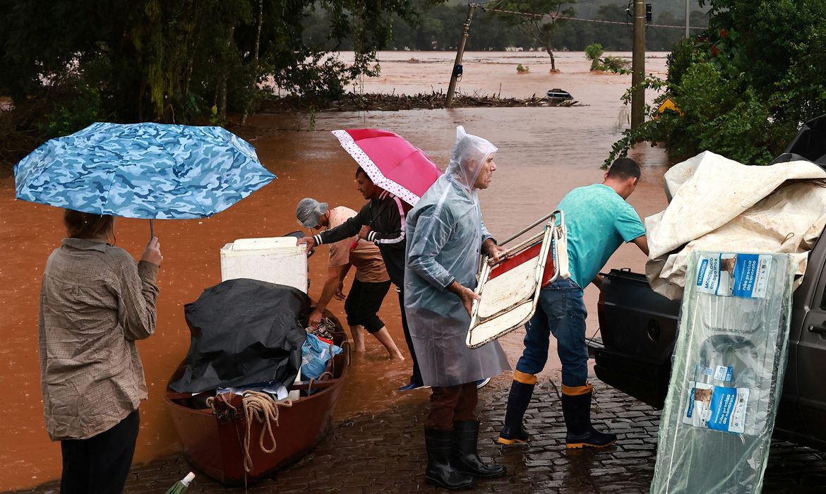 People rescue their belongings near a flooded area next to the Taquari River during heavy rains in the city of Encantado in Rio Grande do Sul, Brazil, May 1, 2024. REUTERS/Diego Vara