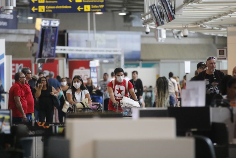 Passageiros e funcionários circulam vestindo máscaras contra o novo coronavírus (Covid-19) no Aeroporto Internacional Tom Jobim- Rio Galeão