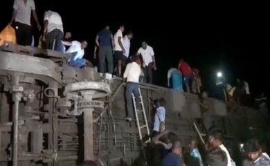 Pessoas tentam escapar de trem descarrilado, em Balasore, Índia