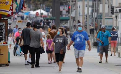 Pessoas que usam máscaras caminham ao longo do cais do oceano enquanto os Estados Unidos passaram na quinta-feira um total de mais de 4 milhões de infecções por coronavírus durante o surto global da doença por coronavírus (COVID-19) em