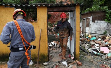 Firefighters dig for victims of a mudslide, where five people died and four remain missing according to the fire department, in Morro do Macaco Molhado (wet monkey hill) in Guaruja