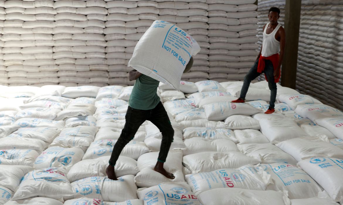 Trabalhadores carregam sacas de grãos enviadas como parte de ajuda humanitária para a Etiópia