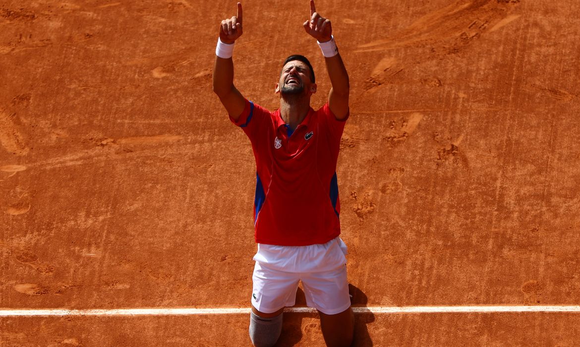 Paris 2024 Olympics - Tennis - Men's Singles Gold Medal Match - Roland-Garros Stadium, Paris, France - August 04, 2024. Novak Djokovic of Serbia celebrates after winning gold against Carlos Alcaraz of Spain. Reuters/Edgar Su/Proibida reprodução