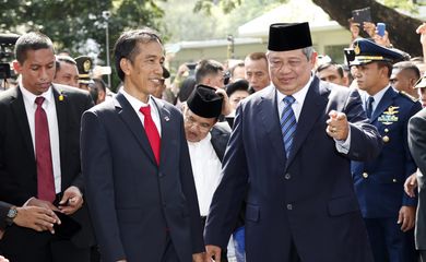 Novo presidente da Indonesia Joko Widodo (à esquerda) é cumprimentado pelo ex-presidente Susilo Bambang Yudhoyono (à direita) em uma cerimônia militar no palácio presidencial, na capital Jacarta