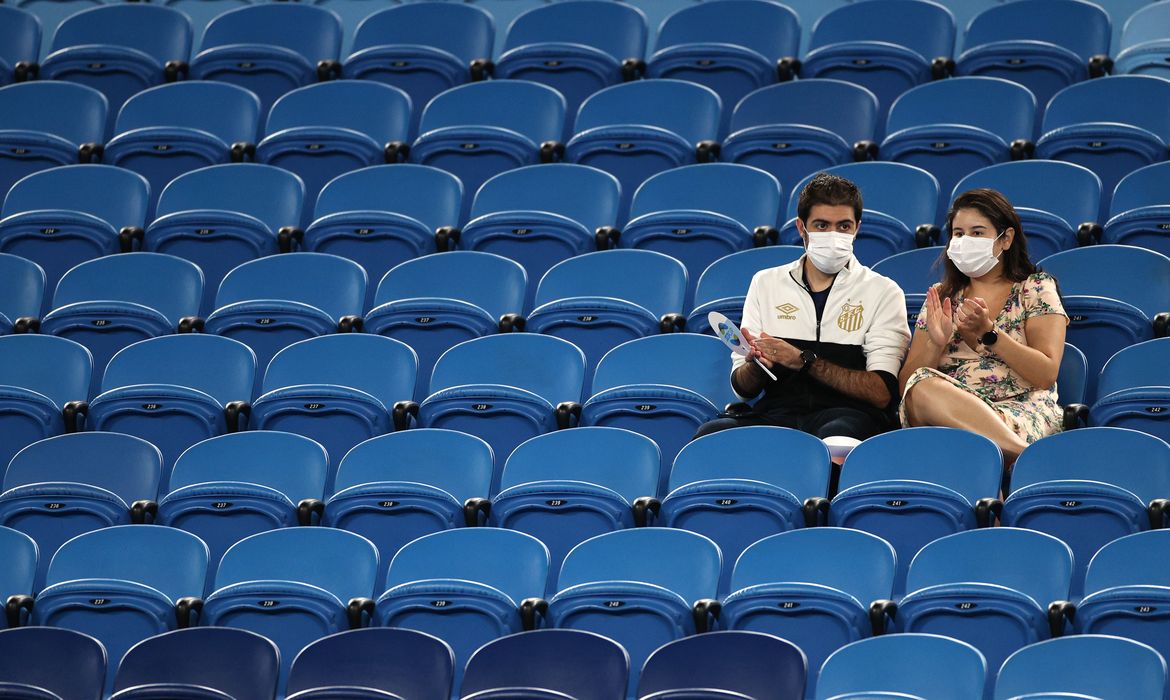 Fãs de máscara assistem a partida no Melbourne Park, na época com público limitado devido às restrições a Covid-19