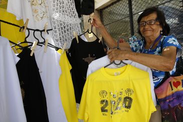 A comerciante Maria Benedita Silva mostra produtos relacionados ao Réveillon na rua do Riachuelo, região central, no último domingo do ano. (Fernando Frazão/Agência Brasil)