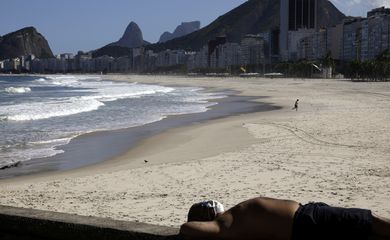 Um homem de máscara protetora relaxa na calçada da praia do Leme durante o surto de doença de coronavírus (COVID-19), no Rio de Janeiro, Brasil, 9 de maio de 2020. REUTERS / Ricardo Moraes
