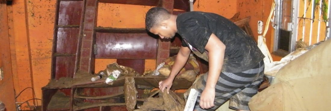 Morador tenta retirar pertences de casa após inundação Grande número de moradores deixou as casas praticamente só com a roupa do corpo
