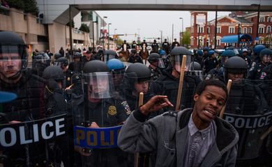 Manifestante se posiciona em frente a policiais durante protesto contra a morte de Freddie Gray in Baltimore, Estados Unidos