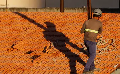Operários reformam telhado de imóvel em obras no Centro do Rio.
