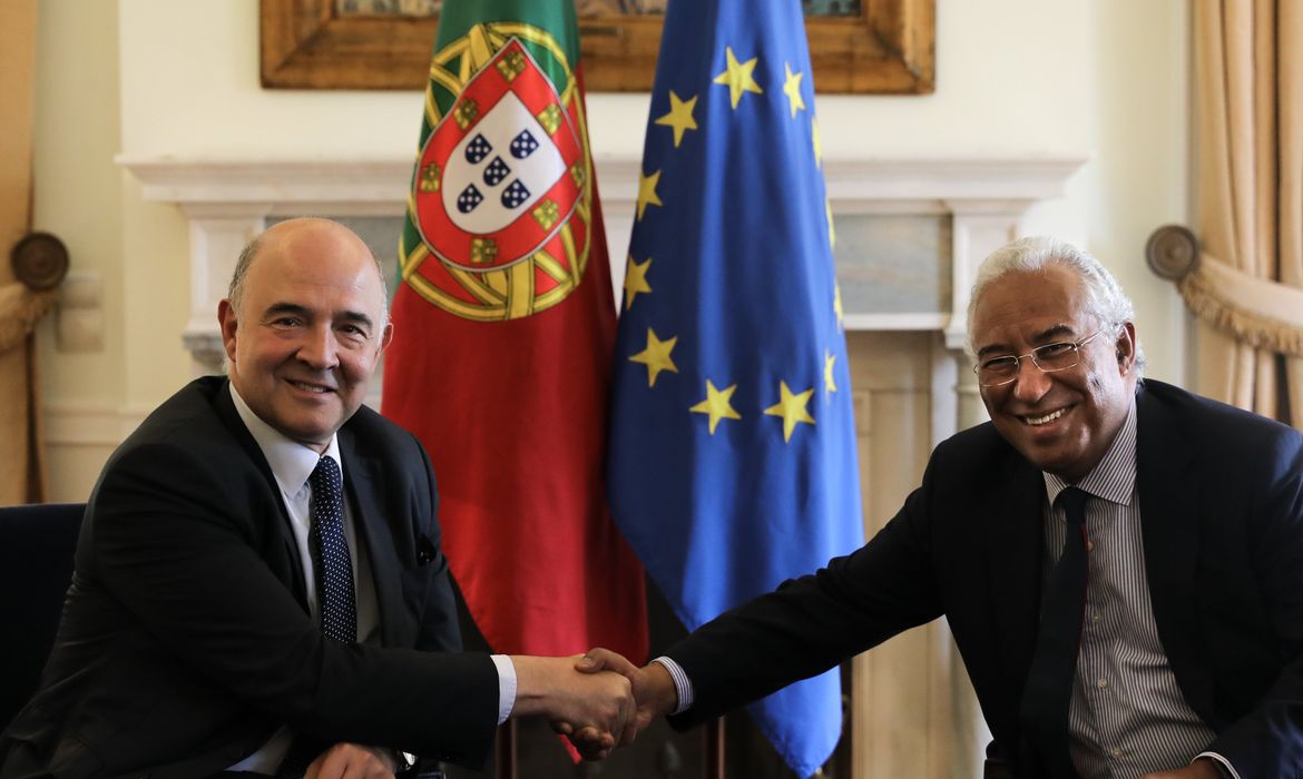 Pierre Moscovici (E), da Comissão Europeia, troca um aperto de mãos com o primeiro-ministro de Portugal, Antonio Costa (D) 