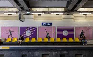 People sit in front of posters of Paralympic athletes at Passy metro station ahead of the Paris 2024 Summer Paralympic Games in Paris, France, August 27, 2024. REUTERS/Umit Bektas