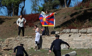 Ativista segura bandeira do Tibete durante cerimônia de acendimento da tocha olímpica dos Jogos de Inverno Pequim 2022