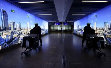 Homem puxa carrinho de bagagem no aeroporto de Frankfurt, na Alemanha