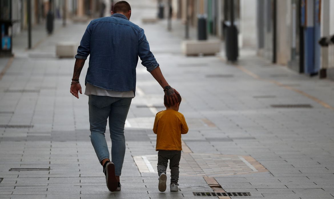 Pai e filho caminham juntos em meio a pandemia de covid-19 na Espanha.