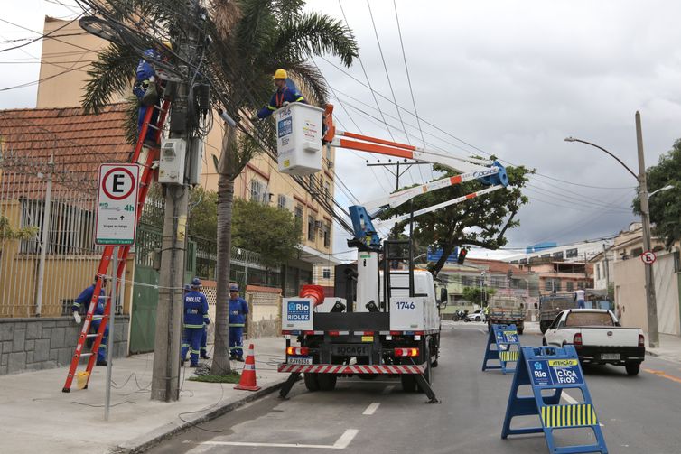 Funcionários da Rioluz trabalham na retirada de fios em Benfica, zona norte da cidade. Prefeitura lança programa Caça-Fios, uma força-tarefa para eliminar fiações que ficam soltas, partidas e caídas nas vias da cidade.