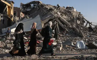 Displaced Palestinians return to their homes as they walk near houses destroyed in an Israeli strike during the conflict, amid the temporary truce between Hamas and Israel, in Khan Younis in the southern Gaza Strip November 24, 2023. Reuters/Ibraheem Abu Mustafa/Proibida reprodução
