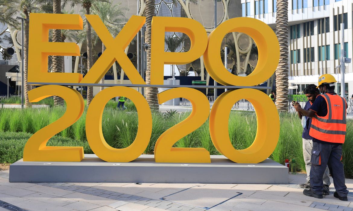 Workers are pictured next to the Expo 2020 logo ahead of the opening ceremony in Dubai