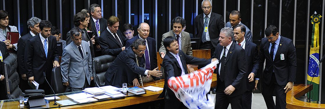 Na Sessão Extraordinária para votar a MP dos Portos, Dep. Toninho Pinheiro (PP-MG) sobe na mesa da presidência com faixa em protesto.
