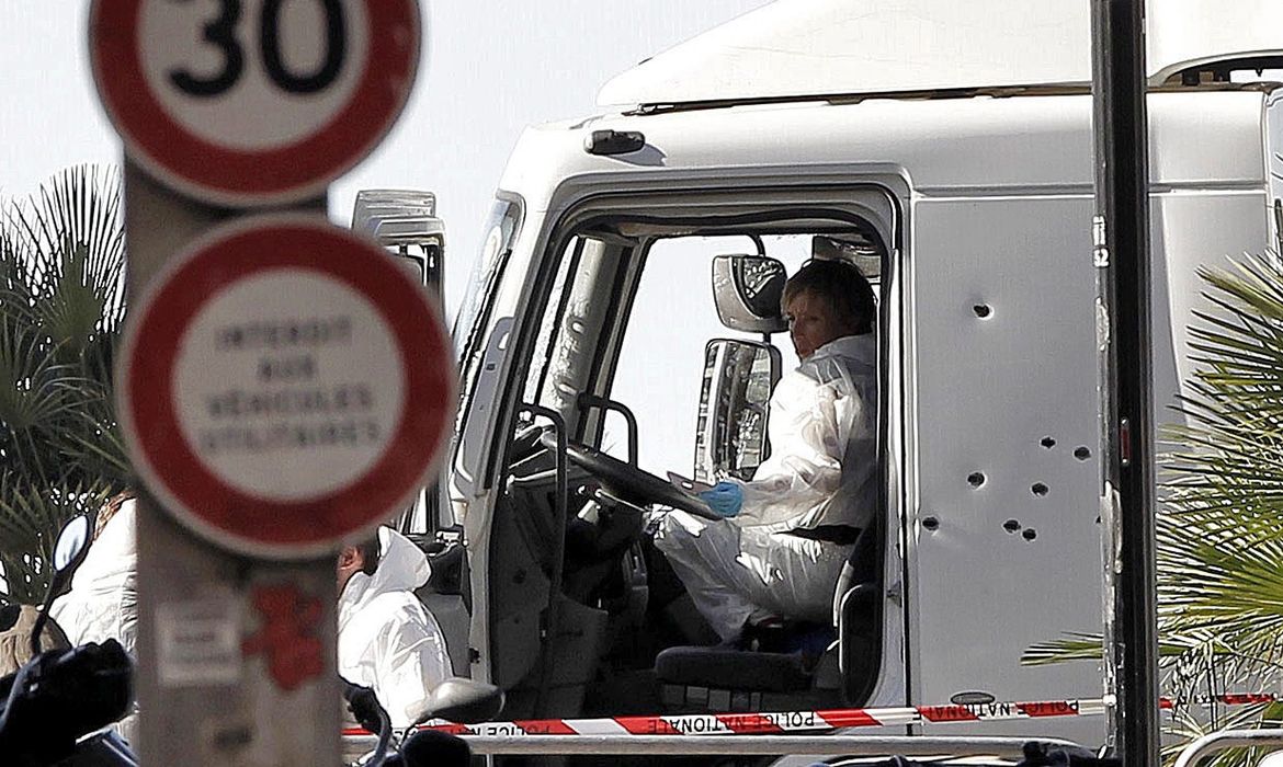 Policiais investigam a cabine do motorista do caminhão que se jogou sobre uma multidão de pessoas que comemoravam a data nacional da França, em Nice