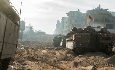 A view shows Israeli military vehicles next to damaged buildings amid the ongoing ground operation of the Israeli army against the Palestinian Islamist group Hamas, in the Gaza Strip, in this handout image released November 18, 2023. Israel Defense Forces/Handout via REUTERS THIS IMAGE HAS BEEN SUPPLIED BY A THIRD PARTY