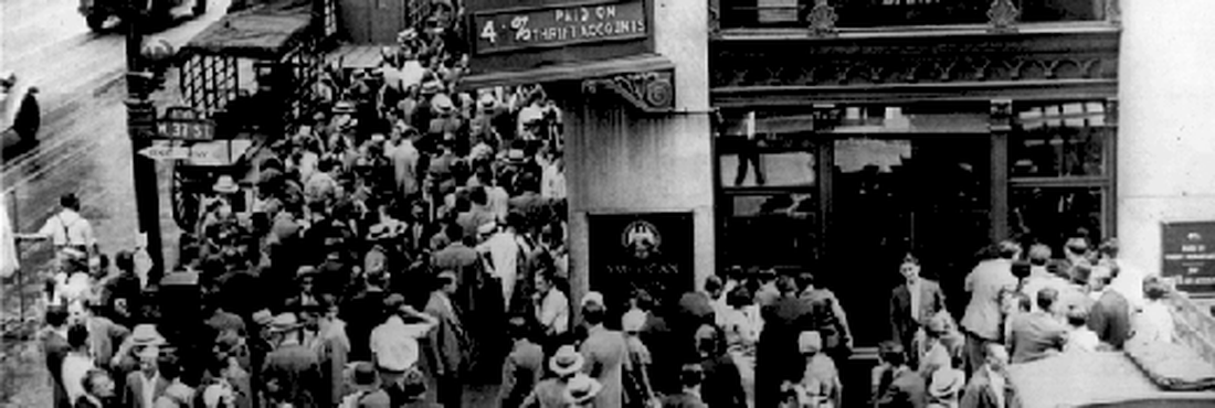 Pessoas reunidas na frente de um banco, durante o período da Grande Depressão. Esse período foi marcado por repentinas perdas de ações e houve casos de suicídio, após acionistas descobrirem que perderam tudo