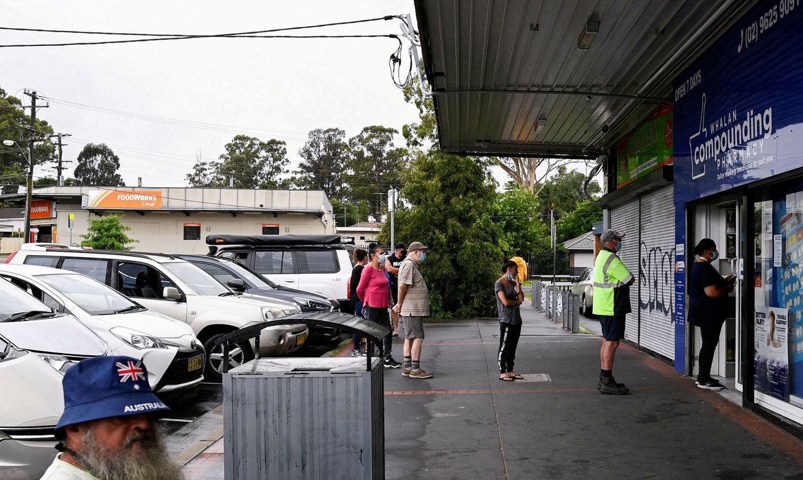 25/07/2022 REUTERS/Direitos reservados Pessoas aguardam por teste de Covid-19 do lado de fora de farmácia, em Sydney, Austrália